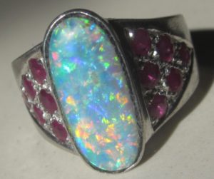 opal ring with 12 rubys on the ring band.