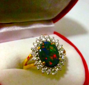 opal ring with diamonds surrounding opal in 18 ^ gold